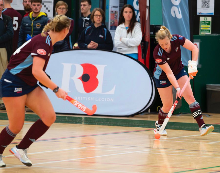 Two RAF servicewomen playing indoor hockey.