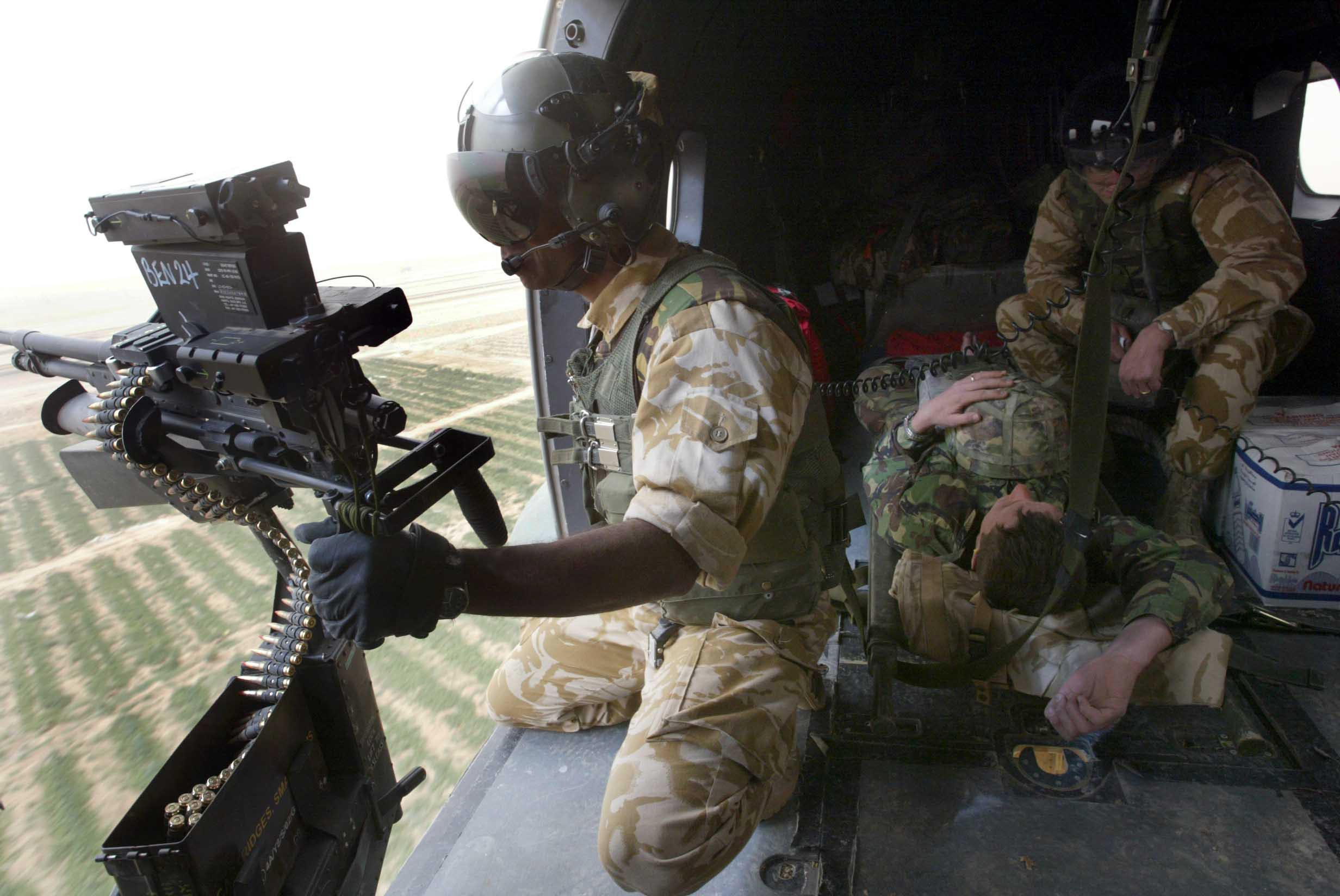 A British soldier clutches his helmet as he is medically evacuated